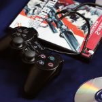 a couple of video game controllers sitting next to a dvd